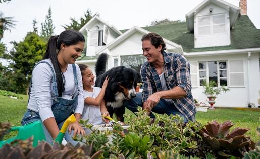 Couple, daughter, and dog in their new home's garden