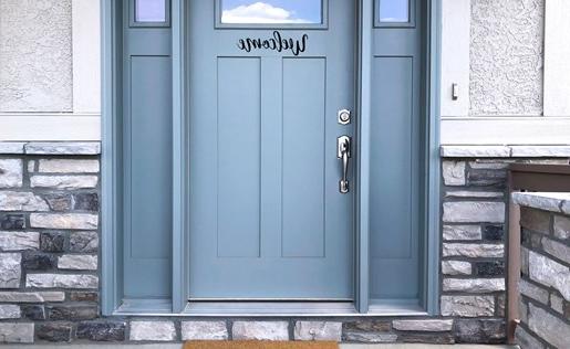 A blue front door with a welcome mat that says "Home"